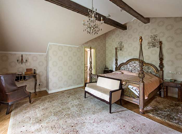 Спальня хозяйки в колониальном стиле с массивной кованой кроватью напоминает восточный будуар