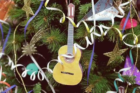 Украшена елка музыкальными игрушками - маленькими гитарами и виниловыми дисками.