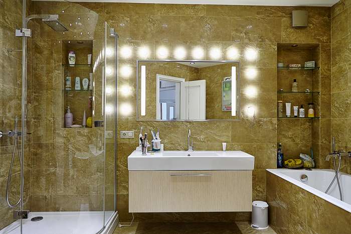 Карамельно-бежевая ванная комната выделяется по цветовому решению: она выполнена в теплых тонах, здесь плитка под натуральный камень