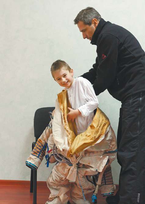 Руководитель ЦПК им. Гагарина Сергей Крикалев помогает надеть скафандр, возможно, будущему космонавту. Руководитель ЦПК им. Гагарина Сергей Крикалев помогает надеть скафандр, возможно, будущему космонавту.