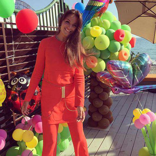 Для детской вечеринки Оксана украсила теплоход множеством воздушных шариков, а сама облачилась в яркий костюм красного цвета. Фото: социальные сети