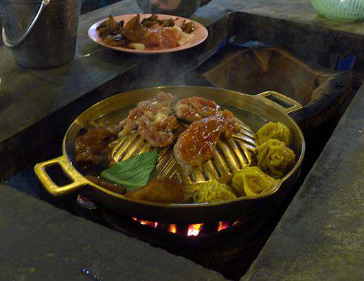 В каждый стол встроена печь, на которой можно готовить хоть жареное мясо, хоть отварные пельмешки.