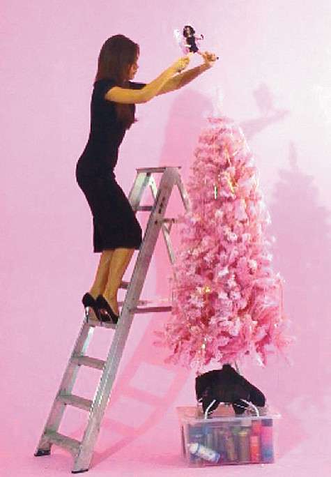 Участвуя в фотосессии, Виктория Бекхэм вызвалась сама нарядить розовую ель. Фото: Twitter.com.