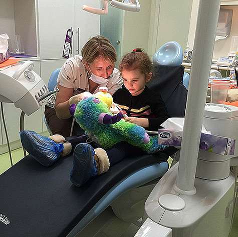 Зубной врач что-то объясняет дочери певицы Славы. Фото: Instagram.com/nastya_slava.
