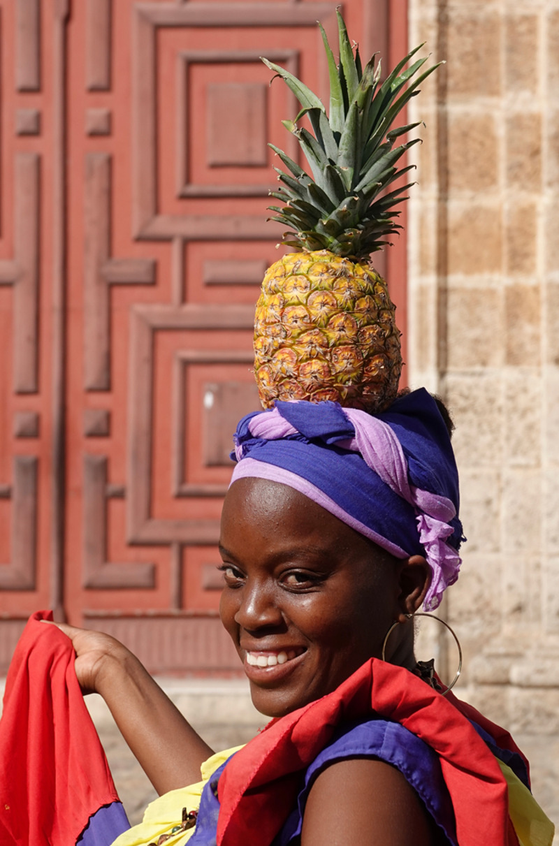 Облаченные в яркие красно-желто-сине-зеленые платья они ждут туристов