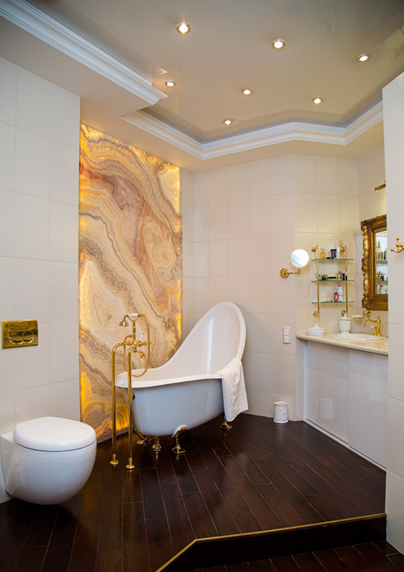Ванная комната поражает своим великолепием: здесь панно из оникса и позолоченная фурнитура. Хотя, по словам хозяйки, сейчас она бы выбрала более лаконичный стиль